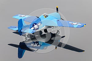 Blue plastic plane on the grey mirror background