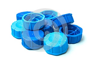 Blue plastic plugs for recycling on white background