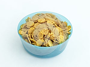 Blue plastic round medium size bowl for loose products filled with cornflakes isolated on a white background