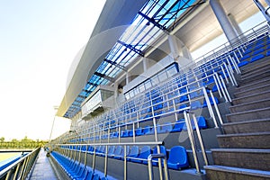 Blue plastic seats. Free arena seating. Empty plastic chairs seats for football fans. VIP lodge in the stadium.