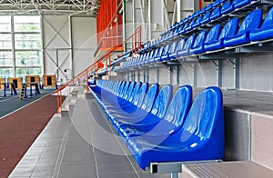 Blue plastic seats in the stadium. Tribune fans. Seats for spectators in the stadium