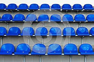 Blue plastic seats in the stadium. Tribune fans. Seats for spectators in the stadium