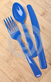 Blue Plastic Silverware on a Wooden Background