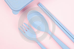 The Blue Plastic spoons, forks and chopsticks set on pink color background