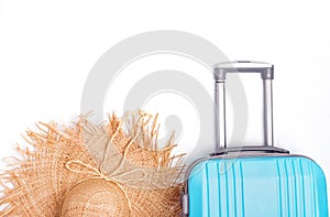 Blue plastic suitcase and straw hat isolated on white background.
