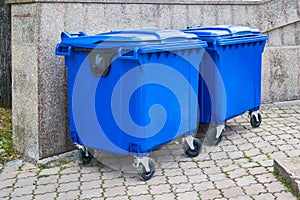 Blue plastic trash recycling containers. Blue containers for collecting garbage on the dustbin