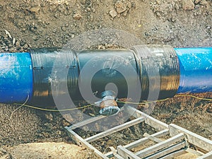 Blue plastic tubes in trench welded together with plastic pipes