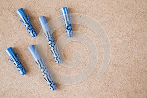 Blue plastic wall plugs on the brown background