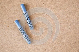 Blue plastic wall plugs on the brown background