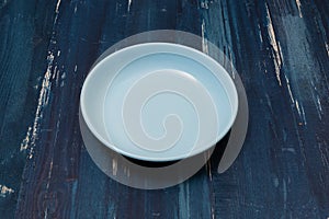 Blue Plate on blue wooden background side view