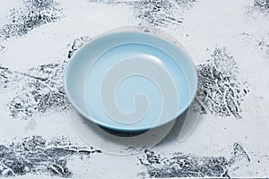 Blue Plate on white scraped wooden background side view