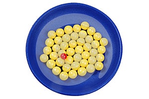 Blue plateful of yellow drops vitamin and red pill