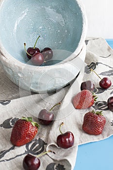 Blue plates with red juicy strawberries and delicious cherries