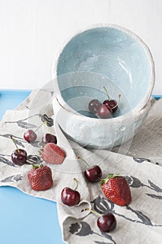 Blue plates with red juicy strawberries and delicious cherries o