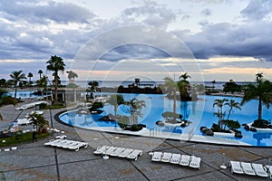 Blue pool on the background of the ocean during sunset. A tourist place of rest and leisure