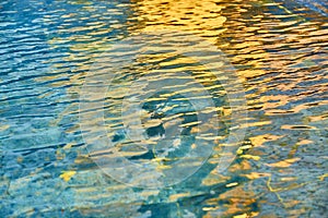 Pool transparent water with sun reflections photo