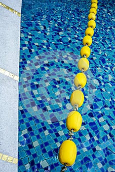 Blue pool water and yellow swimming lane marker in swimming pool
