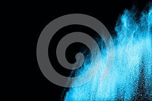 Blue powder explosion on black background.