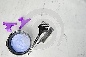 Blue powder hair dye bleaching tools with comb, hair clips and comb on light background. photo