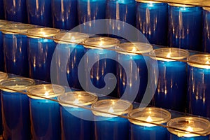 Blue prayer candles burning inside a church