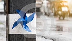 A blue propeller stuck on a light pole and it rains during