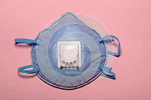 Blue protective mask. Protective mask against a coronavirus outbreak on a pink background. Coronovirus medicine, health and