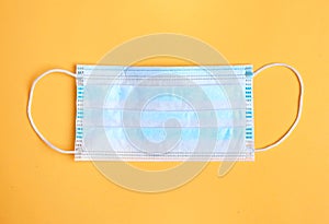 Blue protective medecine mask on yellow background,coronavirus protection