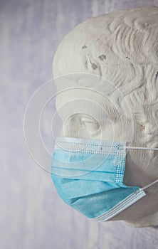 protective medical mask worn on an old Roman statu photo