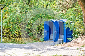 Blue public toilets in the park. open