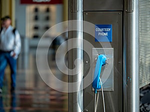 Blue public use courtesy phone located at an airport