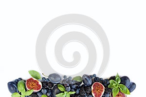 Blue and purple food. Group of fresh fruits and berries with basil`s on a white background.