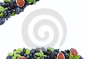 Blue and purple food. Group of fresh fruits and berries with basil`s on a white background.