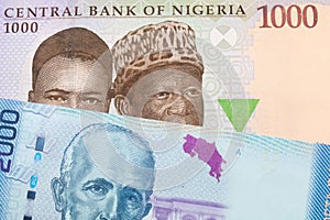 A blue, purple and green one thousand  naira note from Nigeria paired with a colorful two thousand colones bank note from Costa Ri