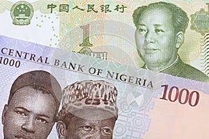 A blue, purple and green one thousand  naira note from Nigeria paired with a green and white one yuan note from China.