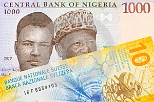A blue, purple and green one thousand  naira note from Nigeria paired with a yellow Swiss ten franc bill.