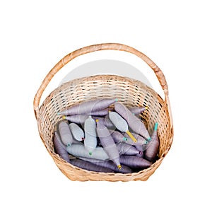 Blue and purple yarn bobbin spools of cotton thread in wood basket isolated on white background with clipping path