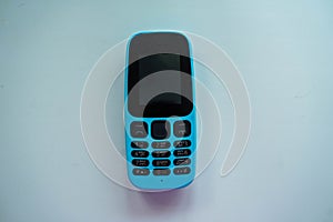 Blue push-button cell phone with black buttons photo