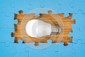 Blue puzzle border with a bright light bulb in the middle