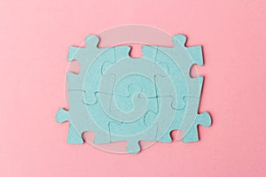 Blue puzzle pieces with empty space for your text and design on pink background