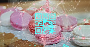 Blue QR code with a red floating web of connections over pink macaronies lying on a table