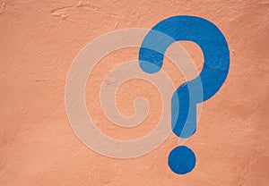 A Blue question mark painted on a sand colored wall in Morrocco photo