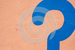 A Blue question mark painted on a sand colored wall in Morrocco photo