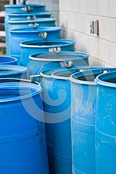 Blue rain barrels in a row flowing into each other