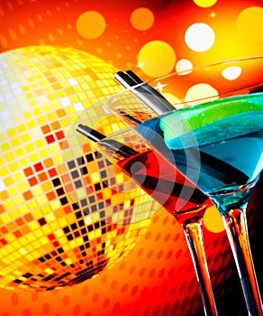 Blue and red cocktail with sparkling disco ball background with space for text selected focus