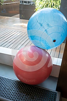 Blue and red exercise balls on metal stand in gym