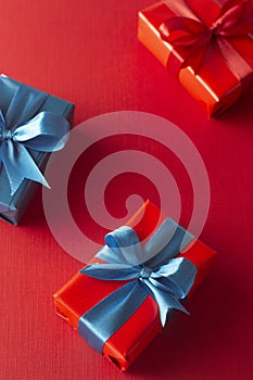 Blue and red gift boxes with red ribbon and bow isolated on red background, top view. Christms, party concept