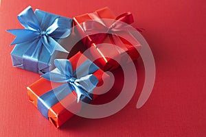 Blue and red gift boxes with red ribbon and bow isolated on red background, top view. Christms, party concept