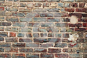Blue and red glazed pained brick wall with vintage brick and patched spots