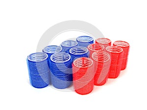 Blue and red hair curlers over white background