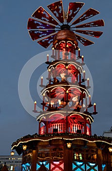 Blue and red night Christmas lights of traditional wooden carousel with catholic nativity scenes in Berlin Germany. Fairy tale